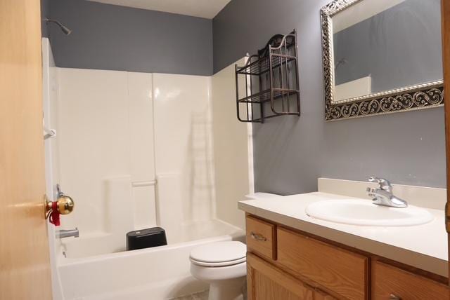 full bathroom featuring shower / bathing tub combination, vanity, and toilet