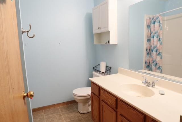 bathroom featuring toilet, vanity, tile patterned floors, and curtained shower