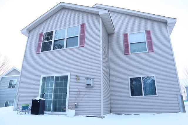 view of snow covered rear of property