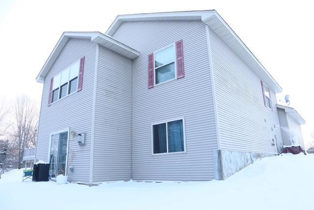 view of snow covered back of property