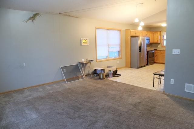 living room featuring light carpet, lofted ceiling, and visible vents