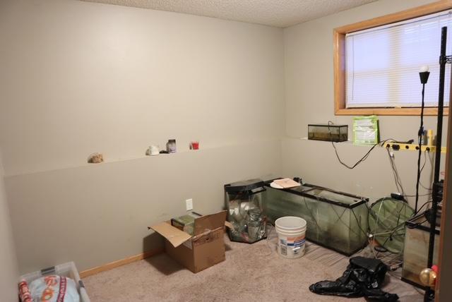 carpeted bedroom featuring a textured ceiling and baseboards