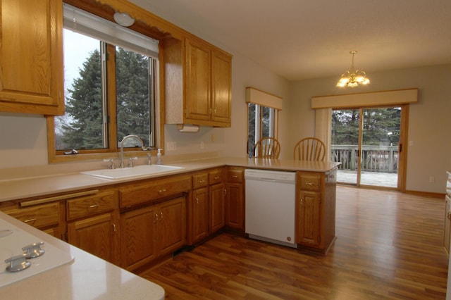 kitchen with kitchen peninsula, dishwasher, decorative light fixtures, a notable chandelier, and sink