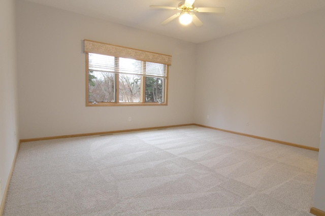 spare room featuring light carpet and ceiling fan