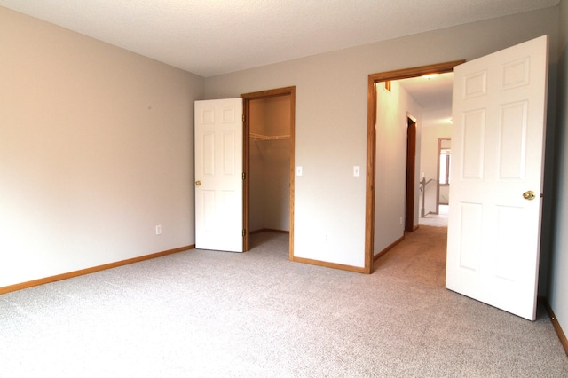 unfurnished bedroom featuring carpet floors, a closet, and a spacious closet