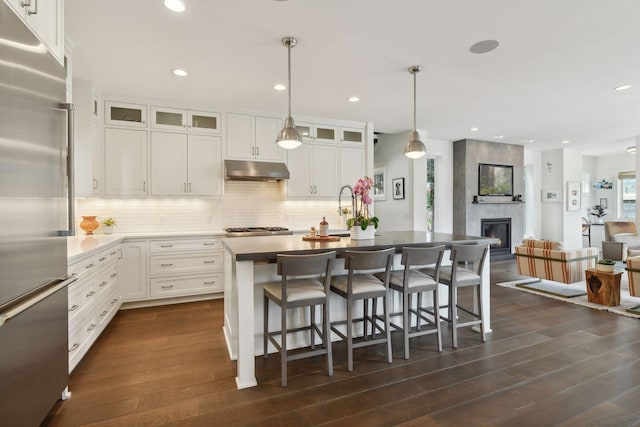 kitchen with a kitchen island with sink, dark hardwood / wood-style flooring, white cabinets, and stainless steel appliances