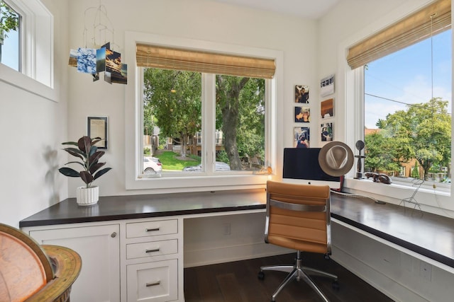 office area with a healthy amount of sunlight, built in desk, and hardwood / wood-style flooring