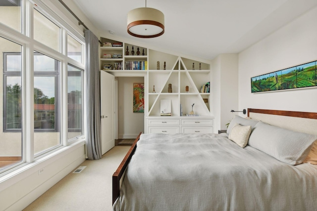 carpeted bedroom featuring multiple windows and lofted ceiling