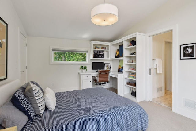 bedroom featuring light carpet, built in desk, and vaulted ceiling