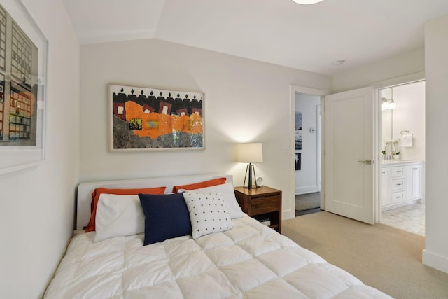 bedroom with carpet flooring, connected bathroom, sink, and lofted ceiling