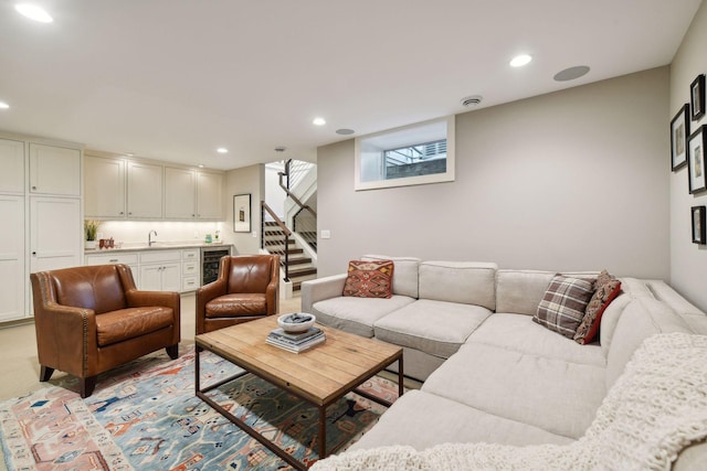 living room with light carpet, wine cooler, and sink