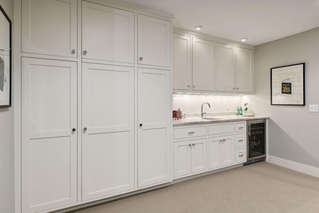 bar with white cabinets, light carpet, and wine cooler