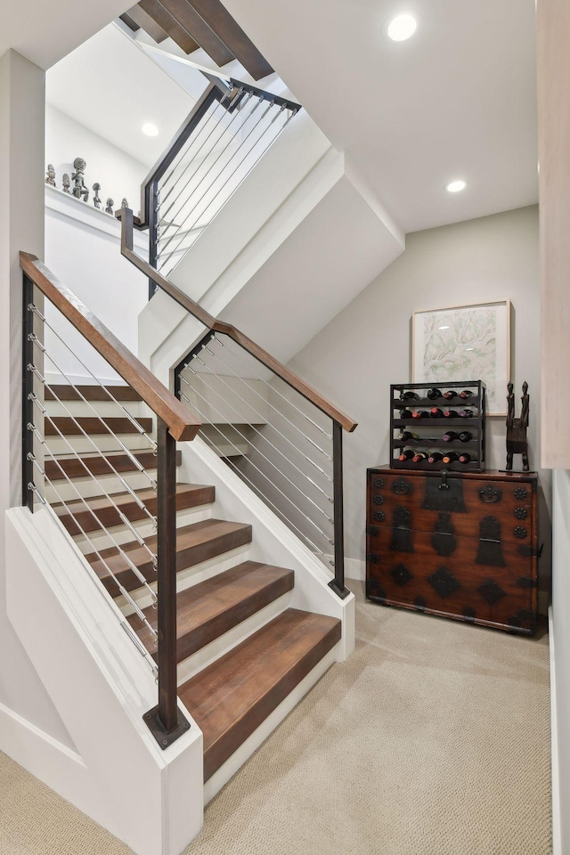 staircase with carpet floors and lofted ceiling