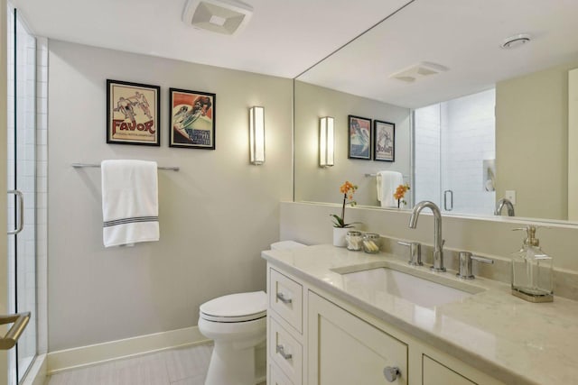 bathroom featuring tile patterned flooring, vanity, toilet, and a shower with shower door