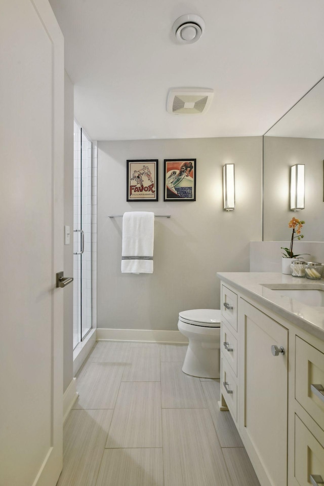 bathroom featuring a shower with door, vanity, and toilet