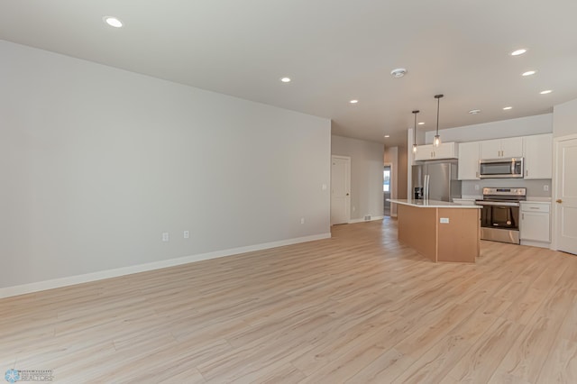 kitchen featuring a center island, stainless steel appliances, light hardwood / wood-style flooring, decorative light fixtures, and white cabinets