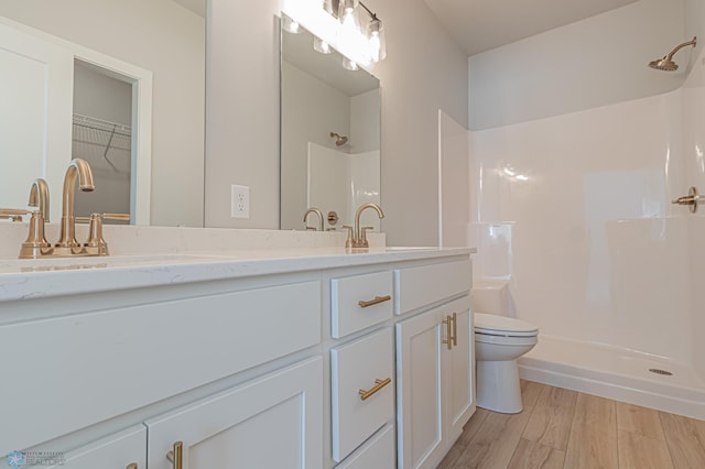 bathroom with vanity, toilet, a shower, and wood-type flooring