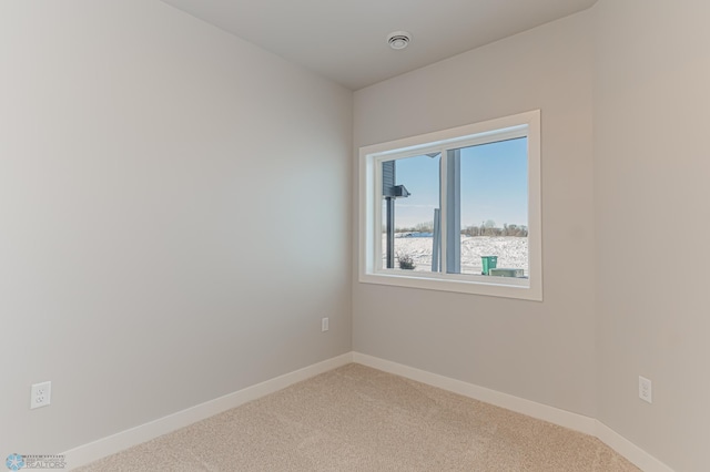 carpeted empty room featuring a water view