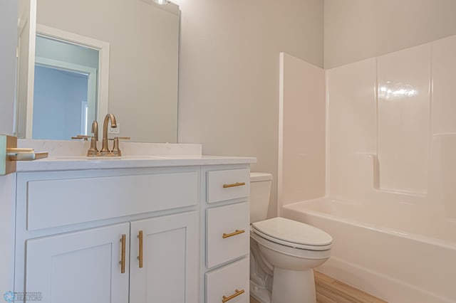 full bathroom with bathing tub / shower combination, hardwood / wood-style floors, vanity, and toilet