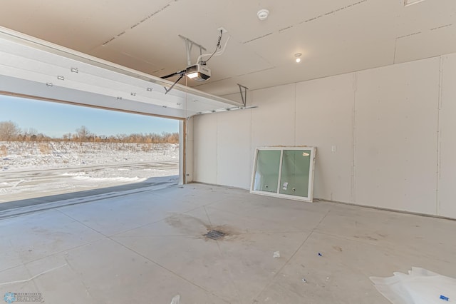 snow covered garage with a garage door opener