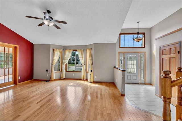 entrance foyer featuring a textured ceiling, light wood-type flooring, and a healthy amount of sunlight