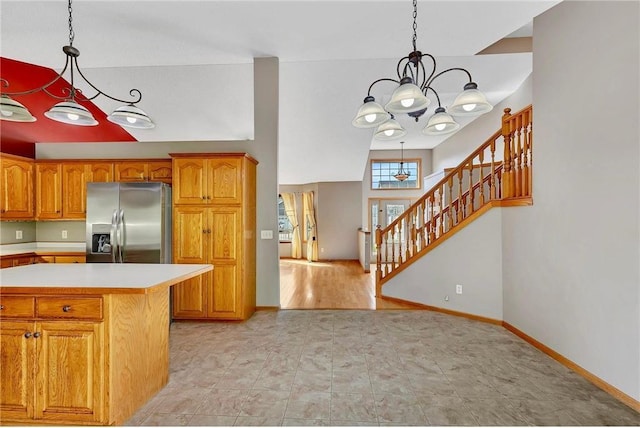 kitchen featuring stainless steel fridge with ice dispenser, light hardwood / wood-style flooring, an inviting chandelier, and pendant lighting