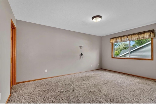 unfurnished room with carpet and a textured ceiling