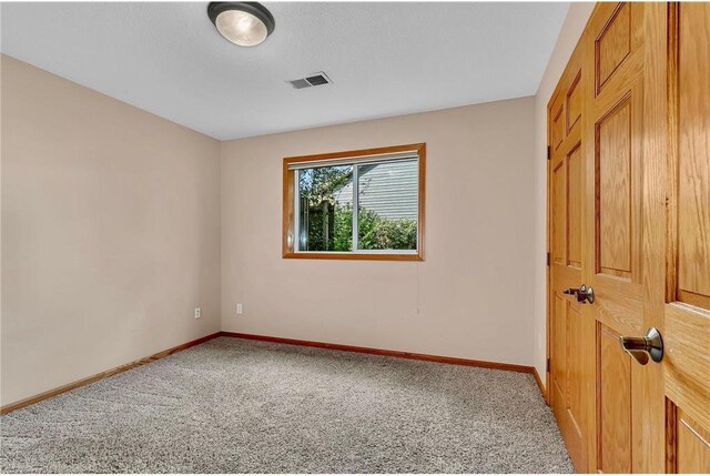 carpeted empty room with a textured ceiling