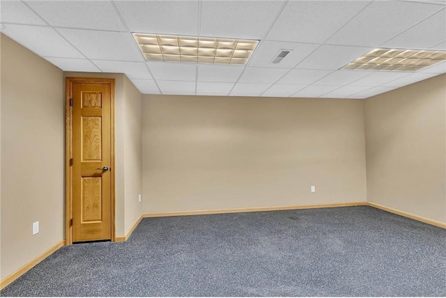 carpeted spare room with a drop ceiling