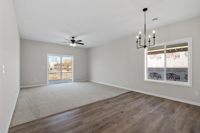 unfurnished room featuring ceiling fan with notable chandelier and hardwood / wood-style flooring