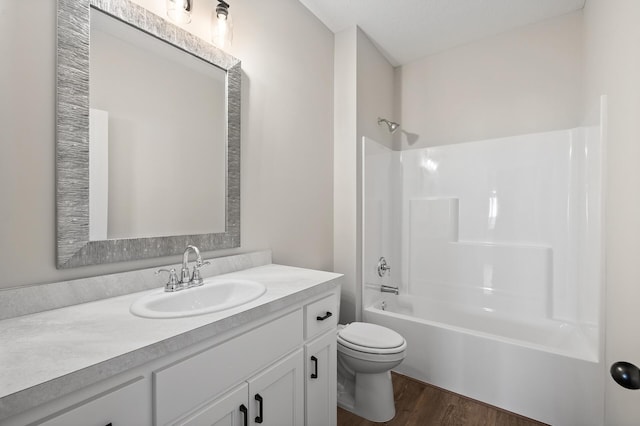 full bathroom with washtub / shower combination, wood-type flooring, vanity, and toilet