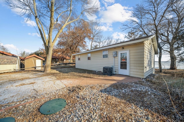 rear view of house with a storage unit