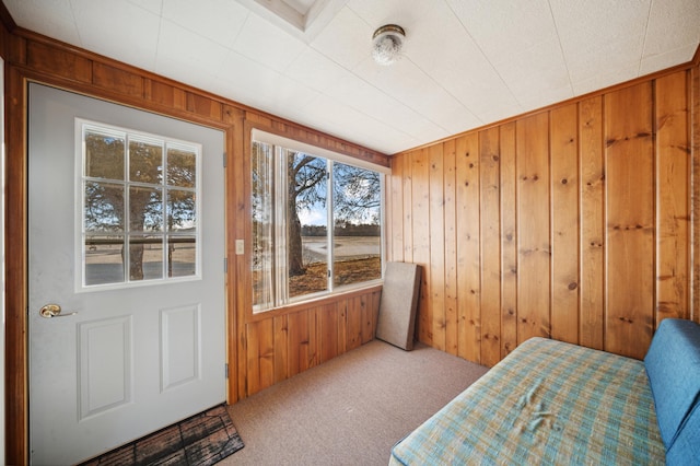 bedroom featuring wood walls and carpet