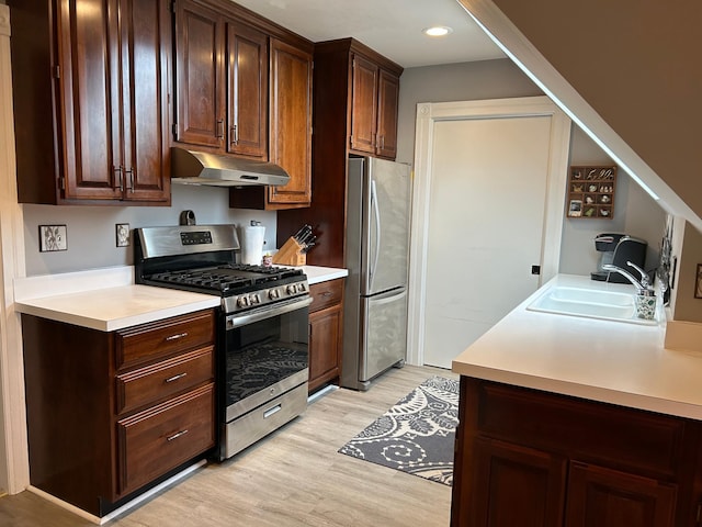 kitchen featuring appliances with stainless steel finishes, light wood-type flooring, dark brown cabinetry, and sink