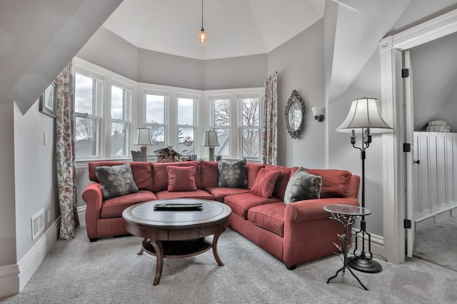 living room with lofted ceiling, light carpet, and a wealth of natural light