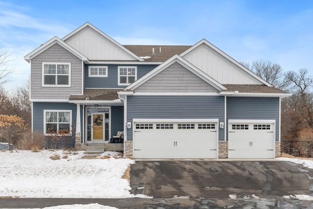 craftsman inspired home with aphalt driveway, an attached garage, stone siding, and roof with shingles