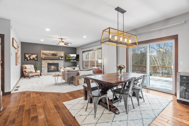 dining space featuring hardwood / wood-style floors, visible vents, recessed lighting, a fireplace, and wine cooler