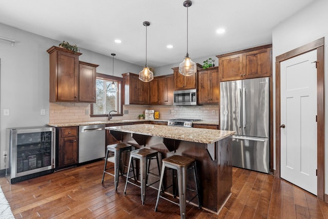 kitchen with beverage cooler, tasteful backsplash, a center island, stainless steel appliances, and dark wood-style flooring