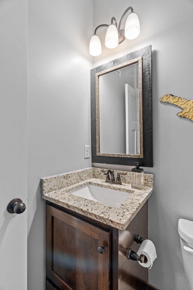 half bath featuring toilet and vanity