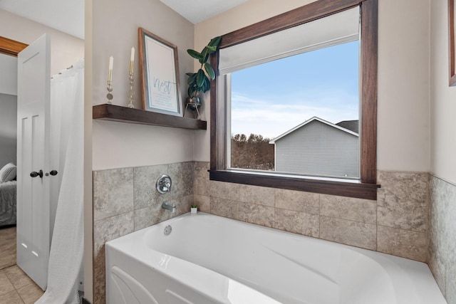 bathroom featuring tile patterned floors and a bath