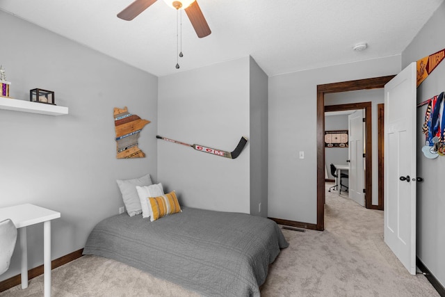 bedroom featuring light colored carpet, baseboards, and ceiling fan