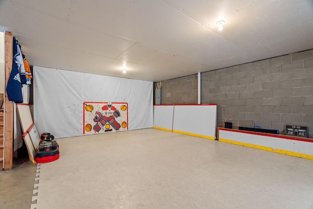 playroom with electric panel, concrete flooring, and concrete block wall