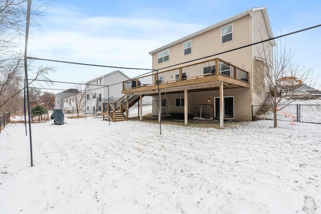 snow covered property featuring stairway, a wooden deck, and fence