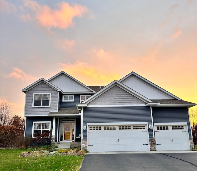 view of front facade featuring a garage, stone siding, and driveway