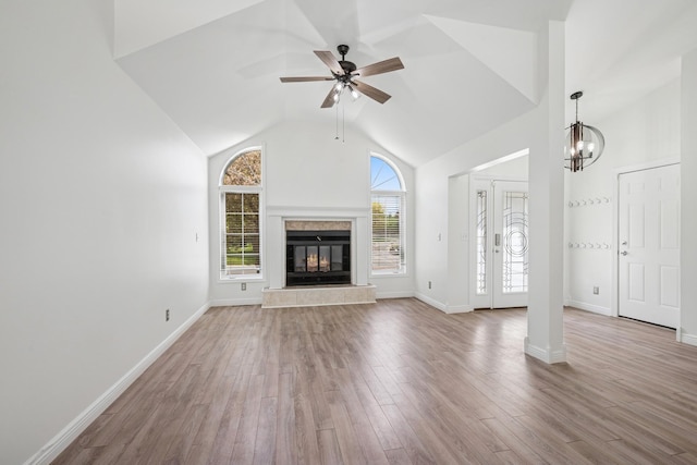 3876 Westbury Ln, Eagan, MN 55123 - unfurnished living room featuring a ceiling fan, high vaulted ceiling, wood finished floors, a tile fireplace, and a chandelier
