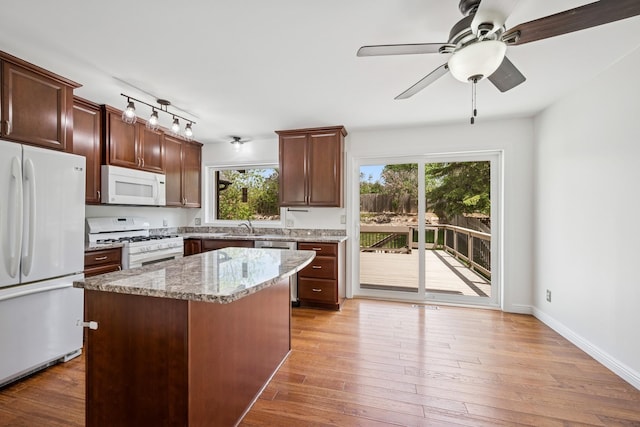 3876 Westbury Ln, Eagan, MN 55123 - kitchen with white appliances, a sink, a center island, light stone countertops, and a ceiling fan