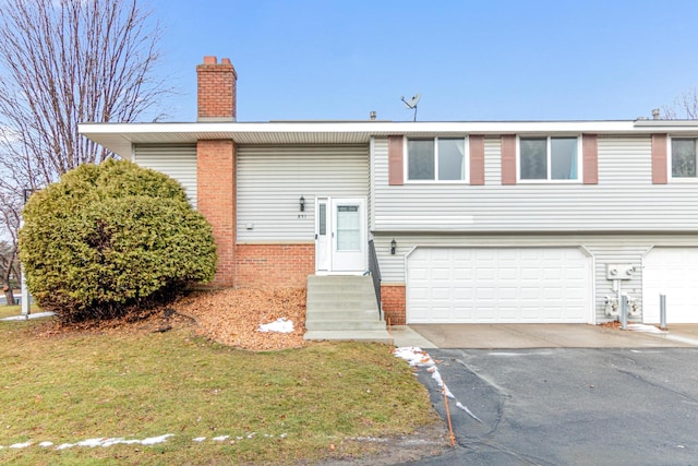 split foyer home featuring a front yard and a garage