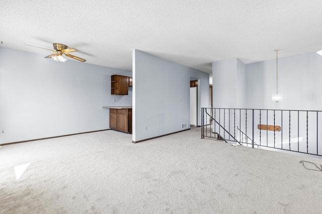 carpeted empty room featuring ceiling fan and a textured ceiling