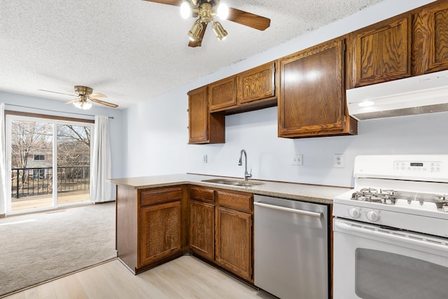 kitchen with sink, stainless steel dishwasher, kitchen peninsula, white gas stove, and a textured ceiling