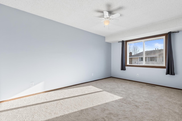 spare room featuring ceiling fan, a textured ceiling, and carpet flooring